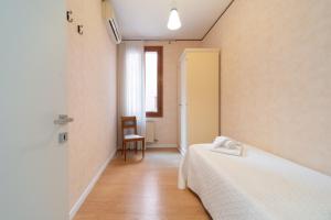 - une chambre avec un lit, une chaise et une fenêtre dans l'établissement San MArtino Apartment, à Venise