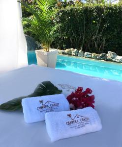 - un ensemble de serviettes sur un lit à côté de la piscine dans l'établissement Cabrera Chalet boutique hotel, à Cabrera