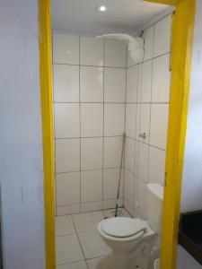 a bathroom with a white toilet in a room at Chalés Recanto dos Pássaros in São Thomé das Letras