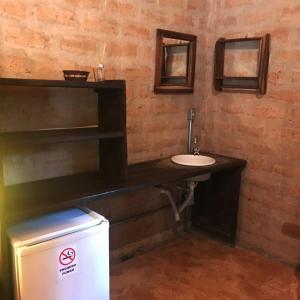 カバルカンテにあるPousada Aldeia Cayanaのレンガの壁に洗面台が付いたバスルーム