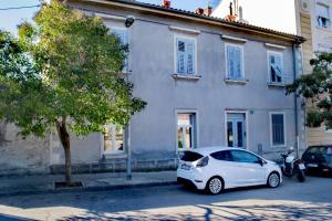 a white car parked in front of a building at Apartman Iva in Pula
