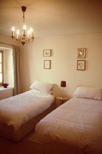 1 dormitorio con 2 camas y lámpara de araña en Loire Escapes - Le Grenier, en Berrie