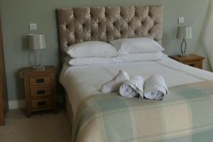 a bedroom with a large bed with towels on it at The Mount B&B in Malton