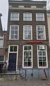 een bakstenen gebouw met een rood bord erop bij Hotel Oldenburg in Zwolle