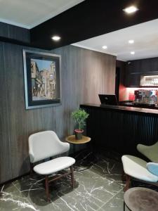 a waiting room with chairs and a laptop on a counter at Hotel H9 in Viña del Mar