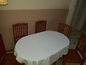une table avec trois chaises et un chiffon de table blanc dans l'établissement Hostel Vienna, au Caire