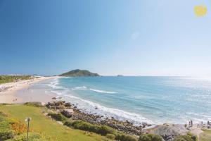 a view of a beach with people walking on the sand at Costao do Santinho Resort All Inclusive in Florian&oacute;polis