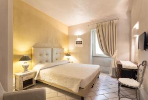 Il Cortiletto Hotel Maison في Tresnuraghes: غرفة نوم بسرير كبير ونافذة
