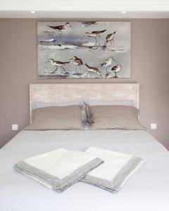 1 dormitorio con 1 cama con pájaros en la pared en Maison d’hôtes Les Ajoncs, en Sainte-Marie-de-Ré