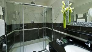
a bathroom with a shower, sink, and mirror at Duca d'Alba Hotel - Chateaux & Hotels Collection in Rome
