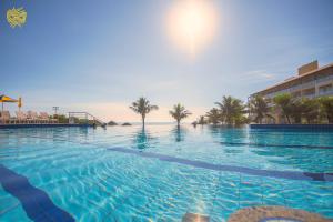 uma piscina com o oceano ao fundo em Costao do Santinho Resort All Inclusive em Florianópolis