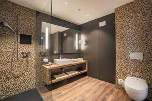 uma casa de banho com um WC, um lavatório e um chuveiro em Self Check-in Hotel von Rotz em Wil