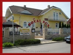 a large yellow house with a sign in front of it at Royal Villa in Balatonfüred