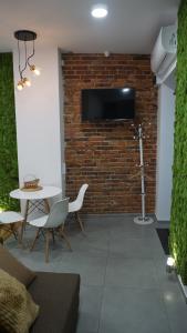 a living room with a brick wall with a flat screen tv at Apartament Starowiślna in Krakow