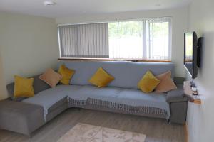 a living room with a gray couch with yellow pillows at Creaggan Ard Guest House in Kyle of Lochalsh