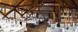a dining room with white tables and chairs at Gostilna Müller in Črnomelj