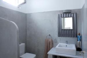 a bathroom with a sink and a toilet and a mirror at Alfa Luxury Villas in Chrissi Akti
