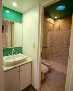 a bathroom with a sink and a toilet and a mirror at Depto 25 las Marías in San Salvador de Jujuy