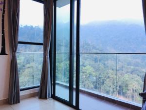 a room with a large window with a mountain view at 12pax Golden Shine Homestay @Midhills Genting in Genting Highlands
