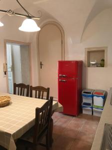 a red refrigerator in a kitchen with a table at Casa Cardi in Sperlonga