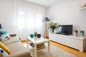 a living room with a couch and a tv at Apartamento Rambla Catalunya in Barcelona