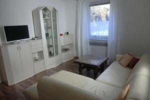 a living room with a white couch and a tv at Casa Papa in Friedberg
