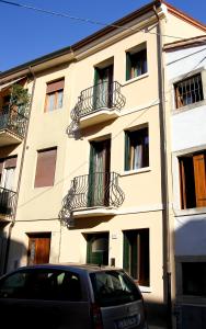 een gebouw met balkons en een auto aan de voorzijde bij B&B San Marco in Lonigo
