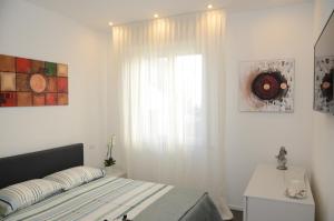 Habitación blanca con cama y ventana en Exclusive Home 2, en Misano Adriatico