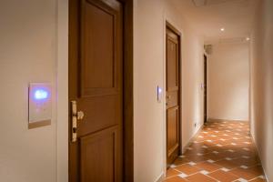 a hallway with a door and a tiled floor at Hotel Atlantic Palace in Florence