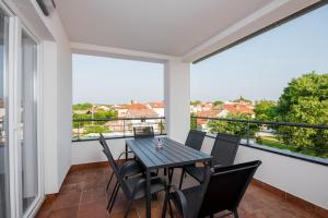 a dining room with a table and chairs on a balcony at Villa Anja 2nd floor in Peroj
