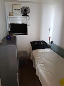 niewielka sypialnia z łóżkiem i kuchenką mikrofalową w obiekcie Drvenik, Apartman 1m from sea w Drveniku
