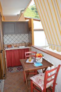 a kitchen with a table and two chairs and a table and a counter at Rosa dei Venti Accomodation in Tropea +54 photos