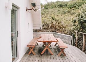 un tavolo da picnic in legno sul portico di una casa di St Francis Cottage close to beach a St Francis Bay