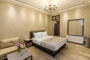 een hotelkamer met een bed en een bank bij Dat Exx Apartments On Liberty Square in Tbilisi City