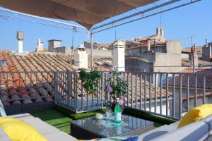 einen Balkon mit einem Tisch und Blick auf ein Stadion in der Unterkunft Arles Holiday - La Terrasse in Arles