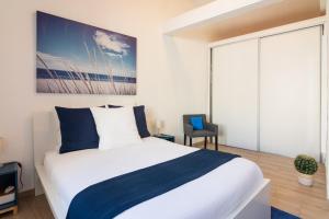 Schlafzimmer mit einem großen Bett mit blauer und weißer Bettwäsche in der Unterkunft Arles Holiday - La Terrasse in Arles