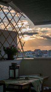 een tafel op een balkon met een zonsondergang op de achtergrond bij Nesting Ramblers SKG #2 in Thessaloniki