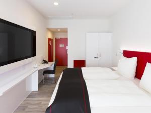 Postel nebo postele na pokoji v ubytování DORMERO Hotel Roth