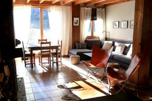 a living room with a couch and a table and chairs at Hotel Lo Paller in Valencia de Aneu