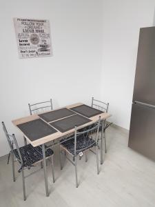 a table with chairs and a refrigerator in a room at Apartament Flo in Constanţa +3 photos