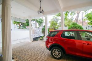una macchina rossa parcheggiata di fronte a una casa di Vivid Colombo a Colombo