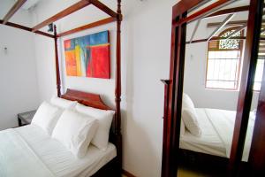 a bedroom with two beds and a mirror at Vivid Colombo in Colombo
