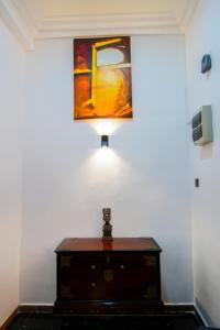 a light on top of a chest in a room with a painting at Vivid Colombo in Colombo
