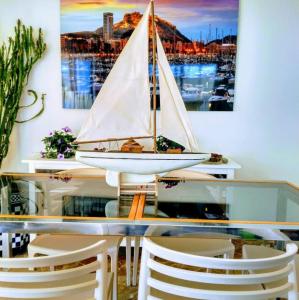 een glazen tafel met een zeilboot erop bij Apartamento Leo Playa de San Juan in Alicante