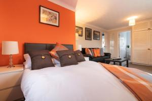 ビスターにあるSt Anne's Serviced Accommodation - Bicester Oxfordshireのオレンジ色の壁のベッドルーム1室、ベッド1台(枕付)
