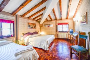 a bedroom with two beds and a table and a chair at Relais Oroscopo in Sansepolcro