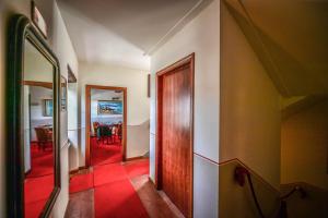 a hallway with a door and a red floor at Relais Oroscopo in Sansepolcro