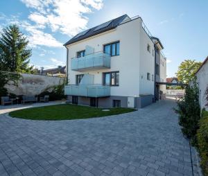 a white house with a brick driveway at WN Rooms in Wiener Neustadt