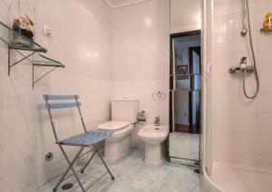 a bathroom with a toilet and a blue chair in it at Azores 19th Floor (180º ocean & city view) in Ponta Delgada +24 photos
