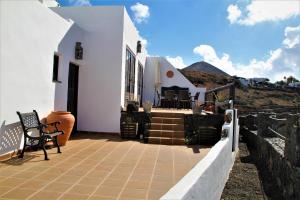 een huis met witte muren en een patio bij Casa Caldera Guiguan in Tinajo
